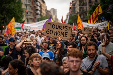 Crowd of people with one banner saying Tourist Go Home