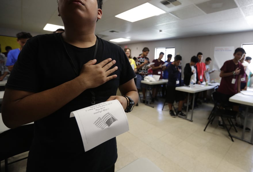 Immigrants say the Pledge of Allegiance in a writing class at the Carrizo Springs holding center in Texas.
