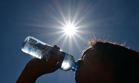 child drinks water under sun