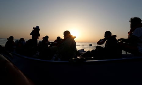 A file photo shows a group of migrants in a boat in the western Mediterranean Sea as Greek police say they rescued a group of naked men close to its northern border with Turkey on Friday.