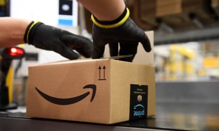 A close up of gloved hands packing an Amazon box