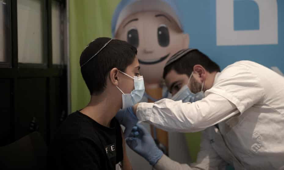 A 14-year-old boy receives a booster shot of the coronavirus vaccine in Jerusalem, Israel.