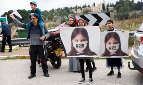 Children hold signs which read “freedom doesn’t look like this” before heading to Jerusalem as part of an Israeli “Freedom Convoy” to protest against Covid-19 restrictions.