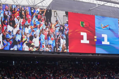 Celebrating DR Congo fans are seen on a big screen after the World Cup group game against Portugal which finished 1-1.