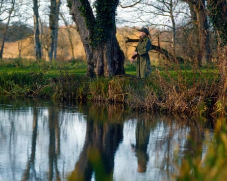 Catherine is reflected in the water of a lake.