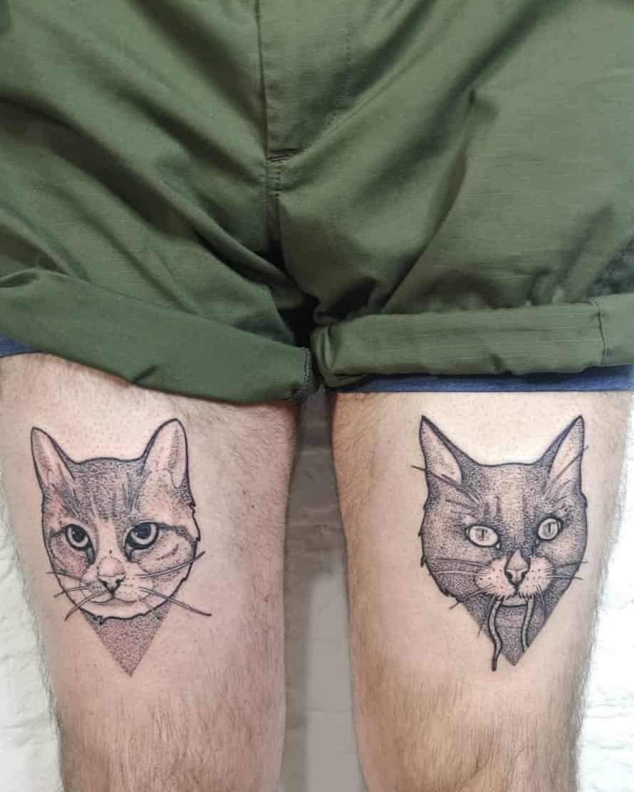 Person in shorts with cat faces tattooed on legs