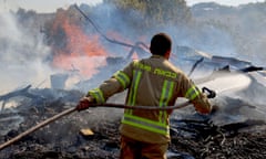 An Israeli firefighter puts out flames in a field after rockets launched from southern Lebanon landed on the outskirts of Kiryat Shmona, on June 4