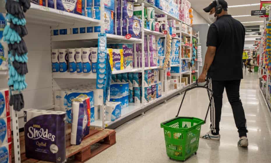 A man walks past the toilet paper in an Asda supermarket in Walthamstow, London as supermarkets urge people not to panic buy.
