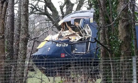 Een trein met een verpletterde bestuurderscabine op de zijkant afgebeeld.