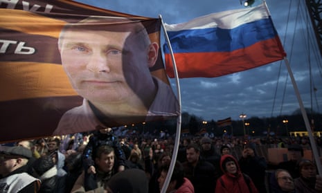 A flag with the portrait of Russian president Vladimir Putin waves over the crowd during the Vesna (Spring) festival in Moscow commemorating the third anniversary of the annexation of Crimea.