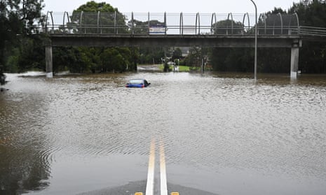 A car is seen abandoned in floodwaters in Lansvale in Western Sydney