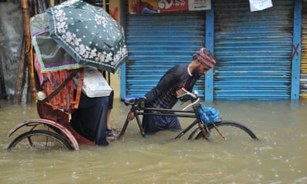 A rickshaw rider navigates a flooded street in Sylhet, Bangladesh