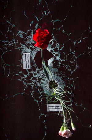 Carnations are placed in the bullet holes in the terrace window of the Carillon restaurant in Paris, France