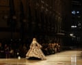 Gigi Hadid walks the runway in an elaborate patterned ballgown inside a grand historic gallery