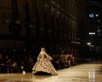 Gigi Hadid walks the runway in an elaborate patterned ballgown inside a grand historic gallery