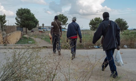 Migrant workers return from the fields in Campobello di Mazara