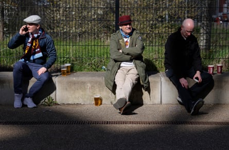 A veteran West Ham sitting outside the stadium with a beer.
