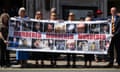 People holding up a sign with pictures of their loved ones who had died after being infected with contaminated blood, reading murdered, murdered, murdered