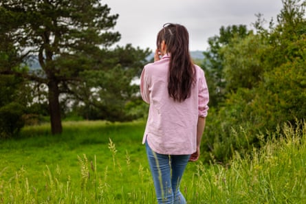 Sasha, daughter of crime writer Christopher Berry-Dee. photographed from behind, surrounded by grass and trees