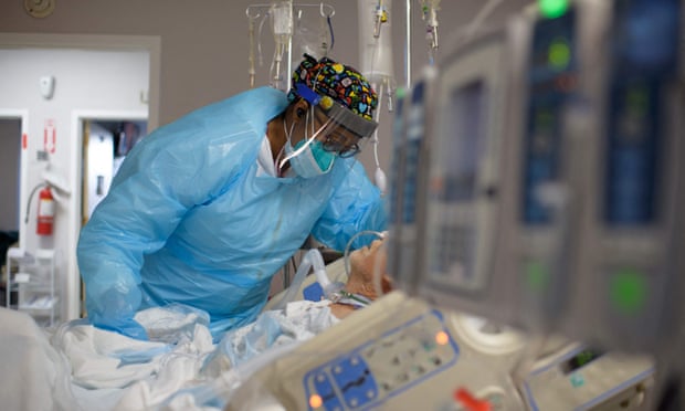 A healthcare worker comforts a Covid patient in Houston, Texas.