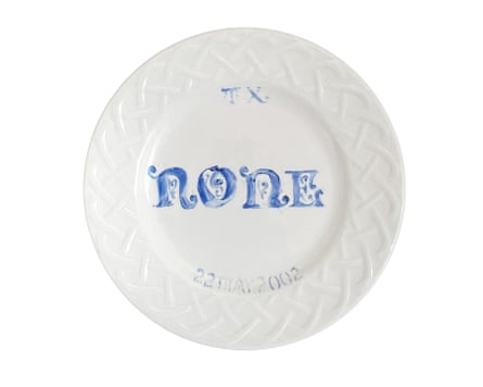 White plate with the word “none” painted in the center