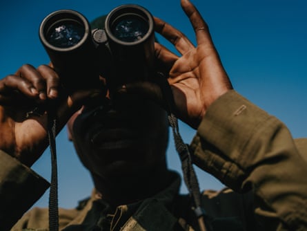 A ranger looks through a pair of binoculars