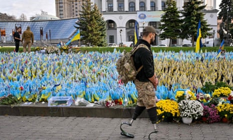 A serviceman, wearing prosthetic legs, walks past the Ukrainian flags symbolising the fallen soldiers on the Independence Square in Kyiv.