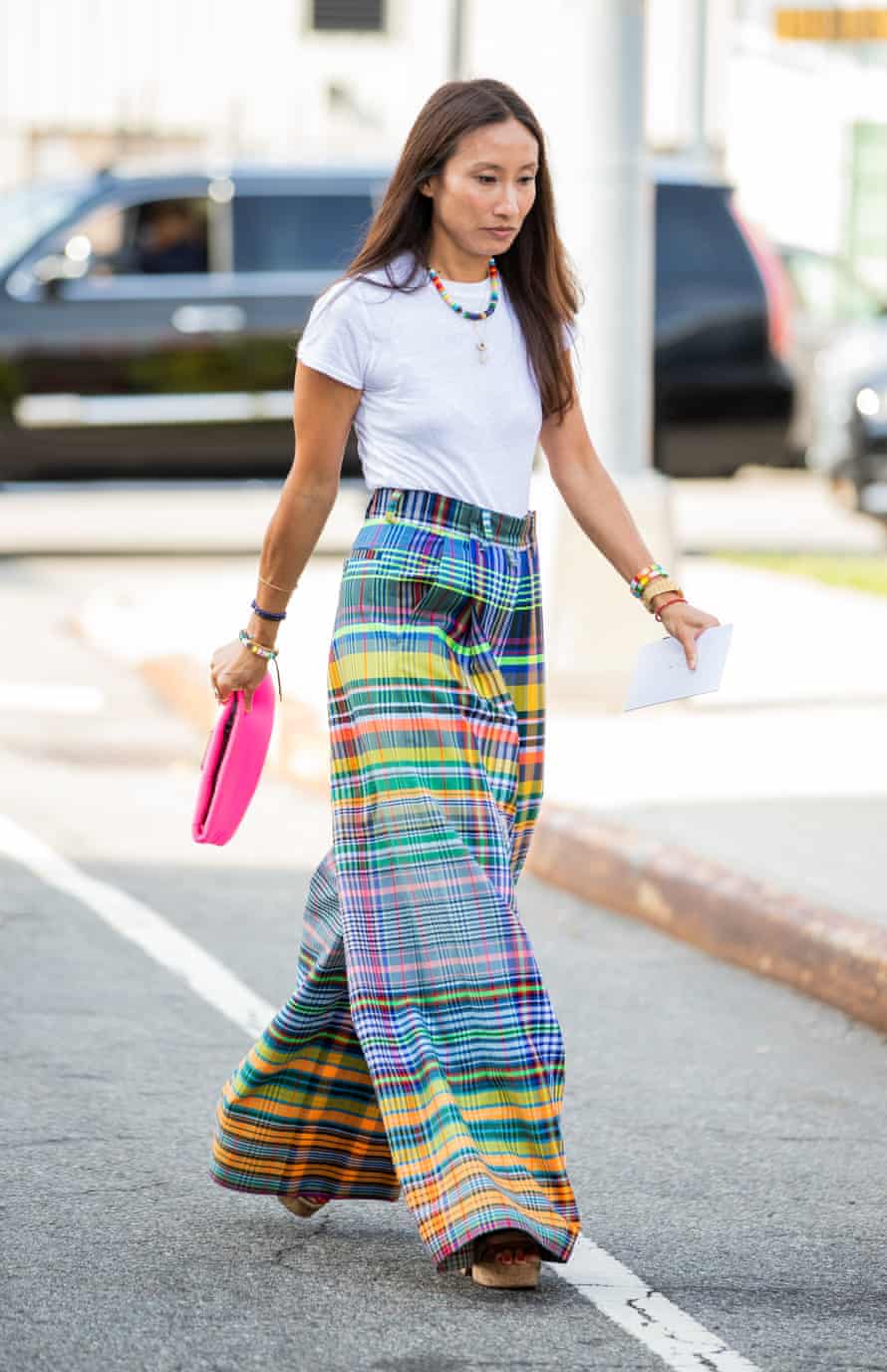 Elizabeth von der Goltz crossing a road in New York wearing multi-coloured plaid trousers and a white T-shirt