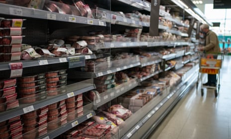 A shopper peruses the meat aisle at a supermarket in London