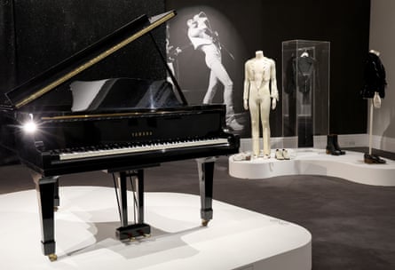 A grand piano and outfits on models in the background