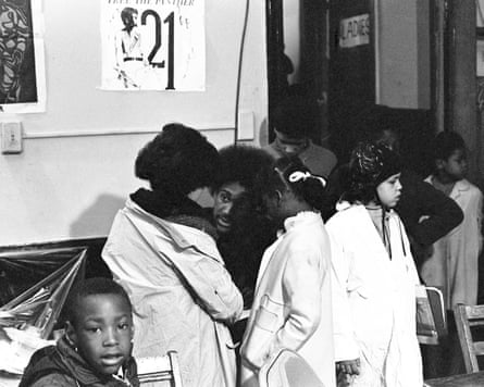 A man helping a group of kids with their coats.