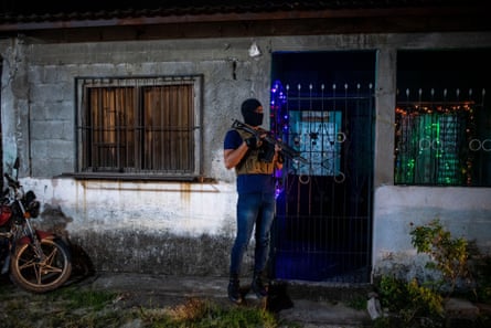 An armed officer stands in front of a property in San Pedro Sula