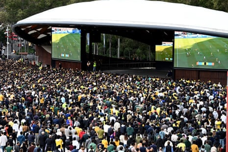 People watching soccer on a huge TV in a big park in Sydney