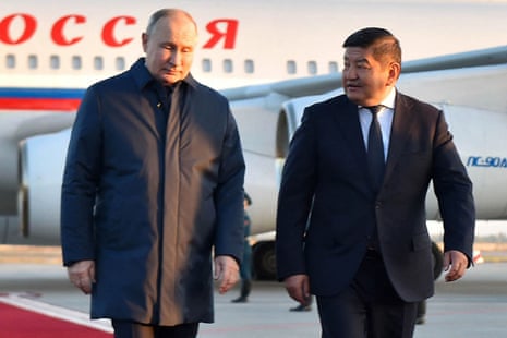Chair of the cabinet of ministers of Kyrgyzstan. Akylbek Zhaparov, (right) walks with Vladimir Putin on his arrival at the Manas international airport in Bishkek.