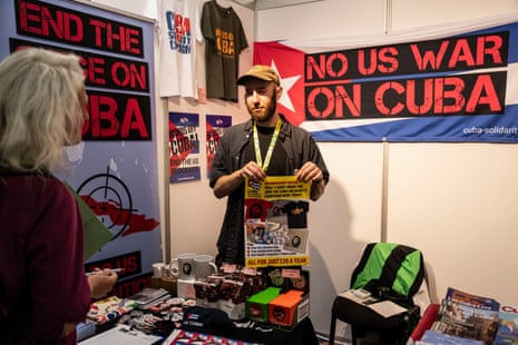 Stallholder στάθηκε μπροστά από μια πινακίδα που έγραφε "Όχι ο πόλεμος των ΗΠΑ στην Κούβα"