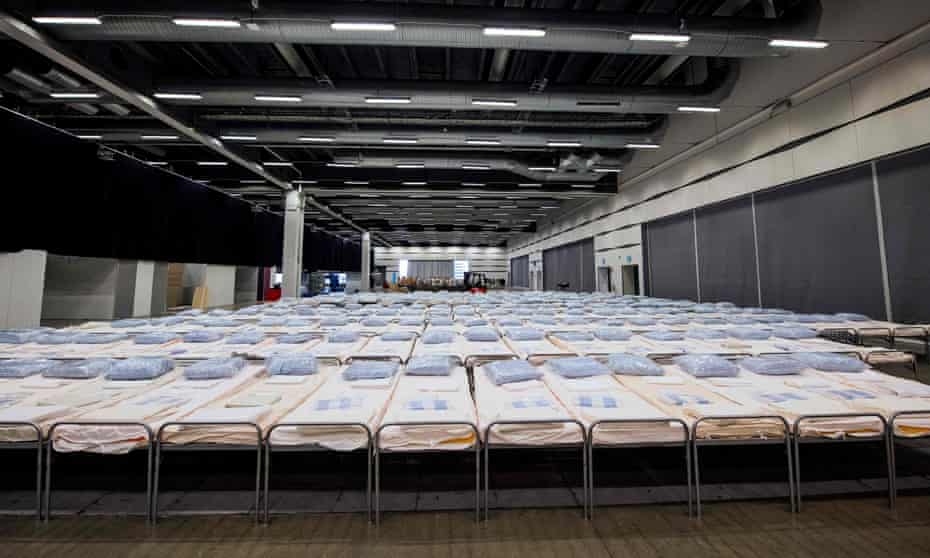 Hundreds of beds for coronavirus patients are lined up to be placed in rooms at a field hospital under construction in the Stockholm International Fairs facility.