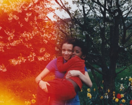 Leah and Bel as children hugging in a garden
