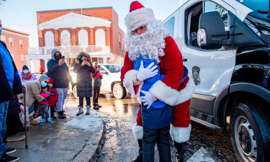 Santa embraces a child at an event for the Grace Food Pantry in Everett, Massachusetts, in December 2020. 