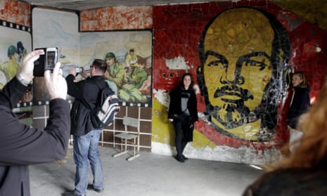 Tourists take photos in front of a mural of Vladimir Lenin in Skrunda-1, a former Soviet secret city in Latvia.