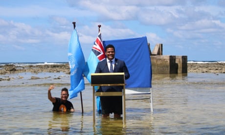 Tuvalu's minister for justice, communication and foreign affairs, Simon Kofe, gives a Cop26 statement while standing in the ocean in Funafuti, Tuvalu.