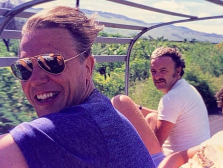 Two men sitting in the back of an open-topped vehicle