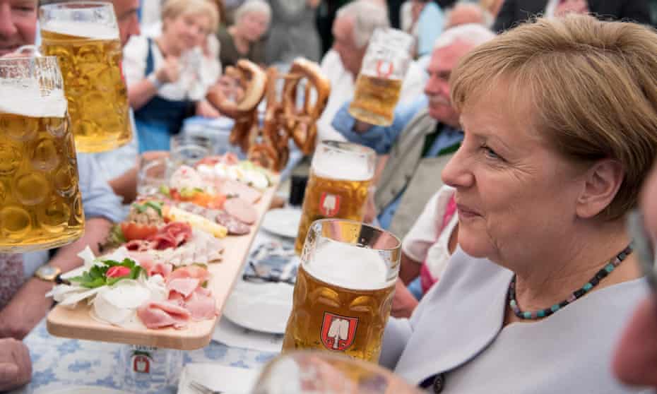 German Chancellor Angela Merkel holds a glass of beer as she attends an election campaign event of the Christian Social Union (CSU), Bavarian sister party of her conservative Christian Democratic Union (CDU)