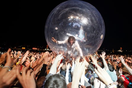 Coyne inside his transparent plastic bubble, being held aloft by the audience’s hands