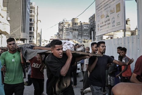 Injured Palestinians, including children, are brought to al-Awda Hospital for medical treatment after the Israeli attacks on a market in the Nuseirat area in the central Gaza Strip.