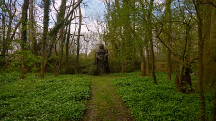 Large beds of wild garlic sit either side of a grassy path leading to a statue of Queen Victoria