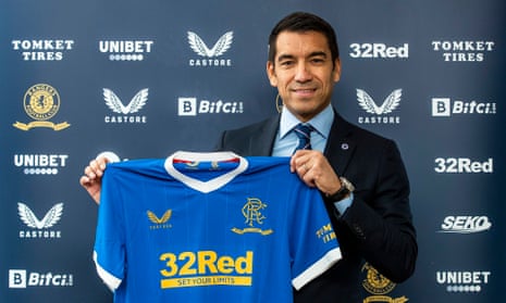 Giovanni van Bronckhorst holds up a Rangers shirt after his appointment