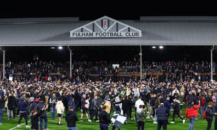 Fulham fans on the pitch at Craven Cottage after full time.