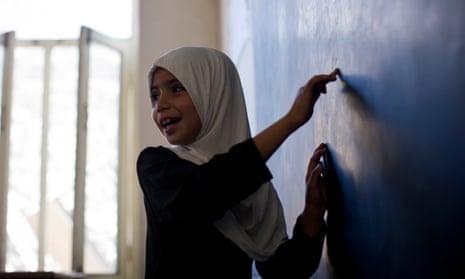 A girl writes on the blackboard at a school in Kandahar, Afghanistan
