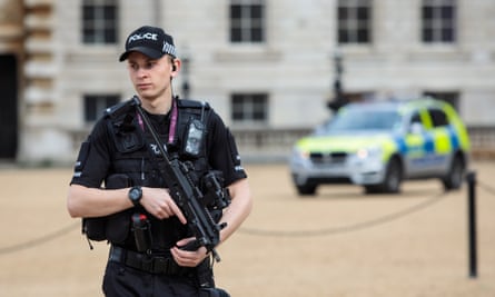 An armed police officer patrols in Horse Guards Parade, central London