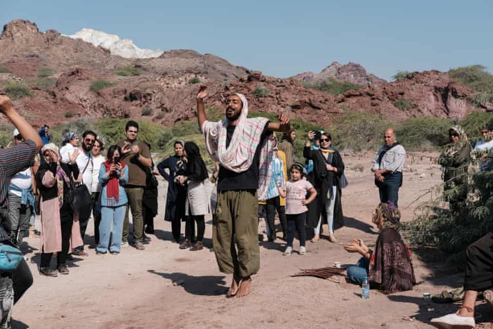 Muhammad sings and dances for a crowd of Iranian tourists. 